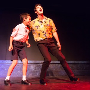 Pictured L to R: Cameron Zener as Young Peter and Justin Genna* as Peter Allen in THE BOY FROM OZ, directed by John Fisher; a Theatre Rhinoceros Production at The Gateway Theatre. Photo by David Wilson.