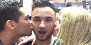 A Man Being Kissed on the Cheek by another man and by a woman